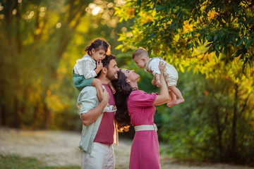 Obraz premium Happy family: mother, father, children son and daughter on nature have a fun on summer day
