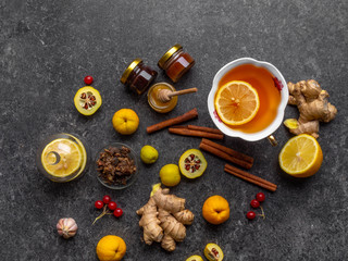 Hot drink with honey, lemon and ginger for cough remedy on concrete background, with propolis in...