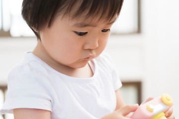 おもちゃのカメラで遊ぶ女の子