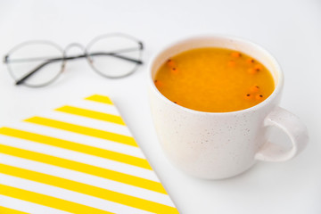 Hot sea buckthorn fruit tea on the desktop. Fall season