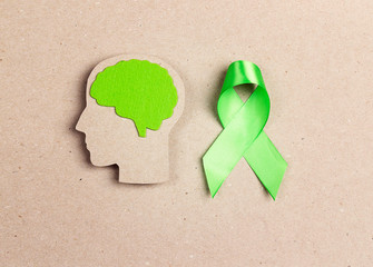 World mental health day concept. Green awareness ribbon and brain symbol.