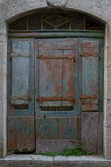 Fototapeta na wymiar Old wooden door painted blue in the village of Labeaume in Ardeche, France.