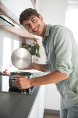 close up. a smiling man looks into a pot of food