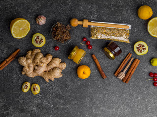 Natural flu and cold remedy ingredients, chamomile flowers, cinnamon sticks, ginger, lemon, honey, cydonia, propolis, garlic Flat lay.