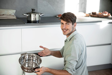 attractive man taking plates out of the kitchen table