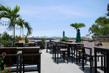 Fototapeta premium Luxury terrace balcony with dining wooden table and chairs and palm tree in a restaurant or resort, Outdoor area, Space for text in template