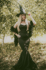 Halloween concept, elegant witch in black dress and hat, costume and ideas on a holidays 