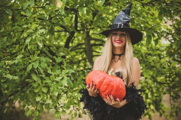 Halloween concept, elegant witch in black dress and hat, costume and ideas on a holidays 