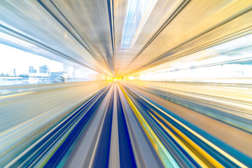 Motion blur of speed train moving in tunnel with light at end.