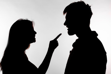 Aggression and abuse concept - man and woman expressing domestic violence in studio silhouette isolated on white background.