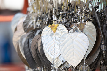 closeup of silver bodhi plate leaf hanging by temple buddhism worshipers for fortune.