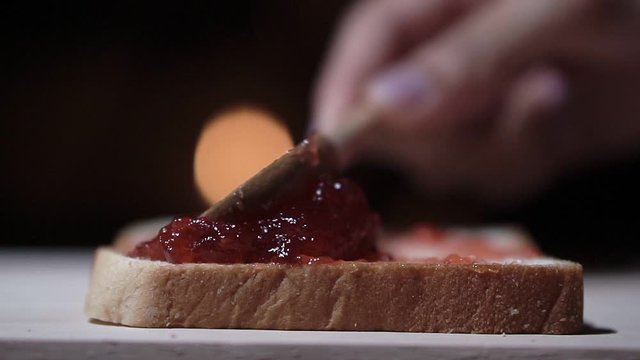 Close up, slow motion clip,Applying strawberry jam on the bread.
