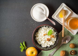 Fresh white cottage cheese in a bowl on the table. Tasty and healthy breakfast. dark stone surface. View from above. A lot of space for text.