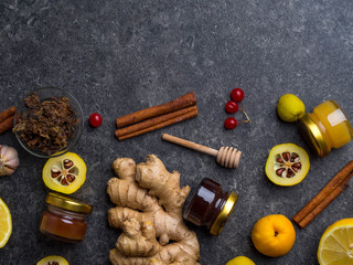 The concept of treating colds with natural resources. Honey. lemon, ginger, cinnamon, viburnum, propolis, cydonia on dark background. Alternative Medicine