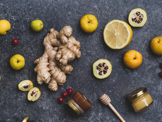 Alternative Medicine, ingredients for a spicy warming tea in the winter day, healthy eating concept, honey in glass jars, red berries, cydonia, lemon, ginger
