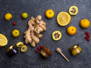 Alternative Medicine, ingredients for a spicy warming tea in the winter day, healthy eating concept, honey in glass jars, red berries, cydonia, lemon, ginger