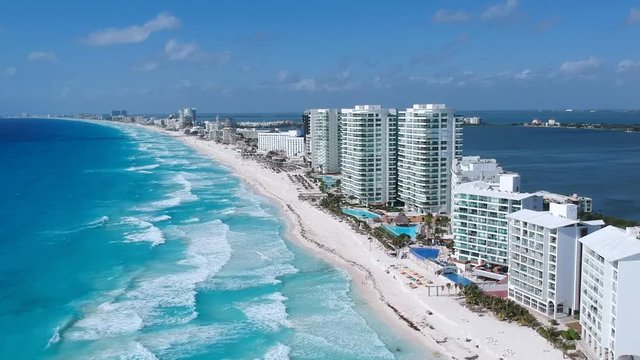 Aerial shot of the hotel zone in canc&uacute;n, in a sunny day hitting the blue waters of the caribbean. Revealing the whole line of hotels going up.