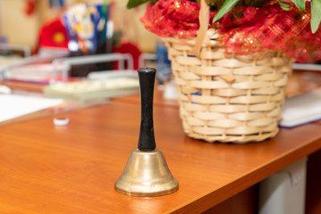 Bell on the wooden table of the teacher at school