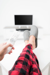 Man looking at TV with legs on the table in living room.