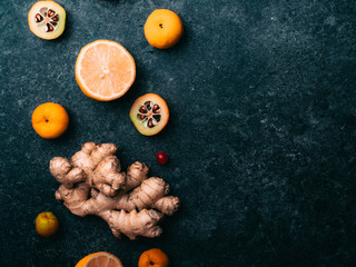 ginger root fresh, lemon slices, red berry, cydoni on concrete background Flat lay style. Place for text. Alternative medicine concept, Healthy food immune boosting selection. 