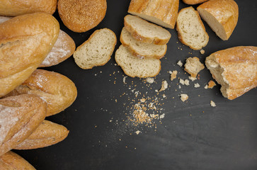 Fresh loaves of bread And sliced ​​bread Placed on a black stone table top view