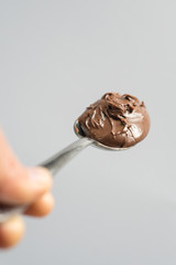 hand holding a spoon of hazelnut spread