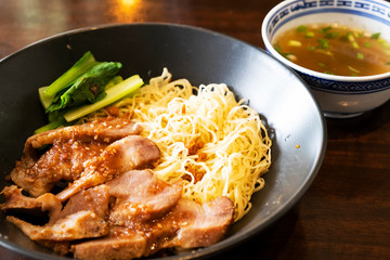 Chinese grilled pork noodles on a wooden table