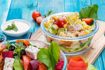 Mixed Vegetable Salads on Blue Wood Background - Mixed Gourmet Food , Mixed Healthy Food - Chicken Salad / Cheese Salad - Green leaves / Salad with Lettuce Leafs on Top and Cherry Tomatoes