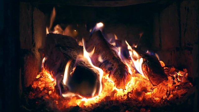 Burning firewood in the fireplace (stove). Live fire in the house.