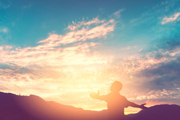 Copy space of man rise hand up on top of mountain and sunset sky abstract background.