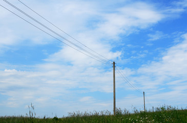 Obraz premium Telegraph poles in the summer meadow