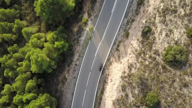 Video of motorcyclist driving his motorbike on the mountain road in the country side. Aerial view.