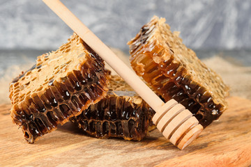 honeycomb with honey on a wooden Board, and a spoon for honey, selective focus