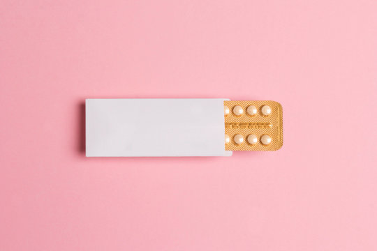 Female oral contraceptive pills blister on pink background. Women contraceptive hormonal birth control pills.