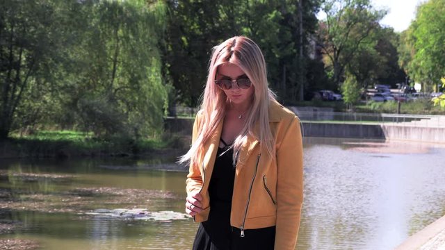 Beautiful blonde in a yellow jacket and sunglasses