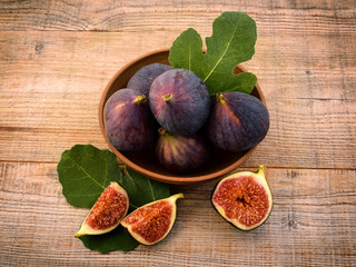 Fresh figs with leaves on an old wooden background. Sweet and healthy fruits. 