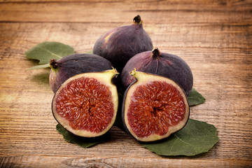 Fresh figs with leaves on an old wooden background. Sweet and healthy fruits. 