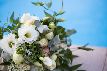 Obraz na płótnie Canvas Wedding bridal bouquet on a blue background close-up.