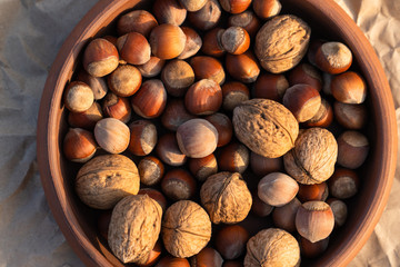 clay plate with nuts of different grades on a background of crumpled craft paper