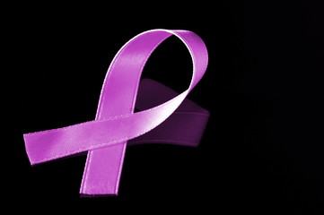 pink ribbon for breast cancer awareness on dark background with copy space
