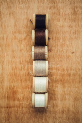 Set of thread on wooden background with copy space for your text