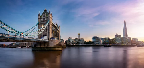 Foto auf Acrylglas Die Tower Brücke in London mit der Skyline entlang der Themse bei Sonnenuntergang, Großbritannien © moofushi