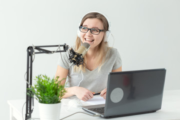 Radio, blogging, podcasting concept - young woman working as a dj on the radio.
