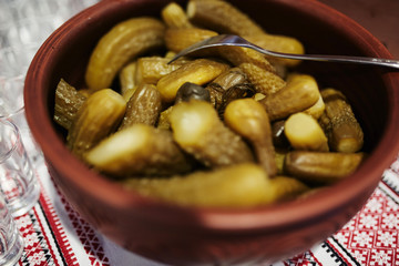 Fresh prepared homemade pickled cucumbers with spices in clay pot. Soft focus.