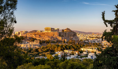 View to the Parthenon Temple at the Acropolis of Athens above the old town Plaka during sunset time, Greece