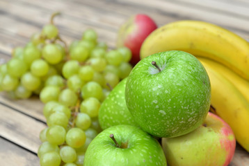 Obraz na płótnie Canvas close on green apple on a heap of fruits on a table