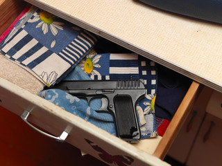 handgun in a cupboard drawer - obrazy, fototapety, plakaty
