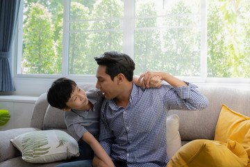 Asian family father and son playing together in living room, happy family concept