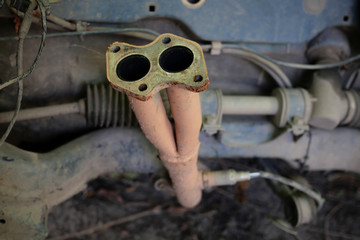 Parts of an old rusty abandoned car. Various disassembled parts and mechanisms.