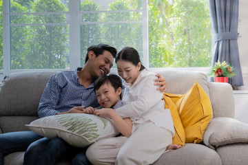 Asian family father, mother and son playing together in living room, happy family concept